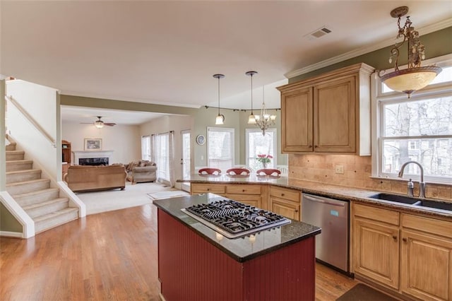 kitchen featuring sink, hanging light fixtures, a center island, stainless steel appliances, and light hardwood / wood-style flooring