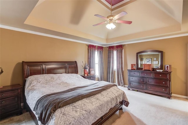 bedroom featuring light carpet, a tray ceiling, ornamental molding, and ceiling fan