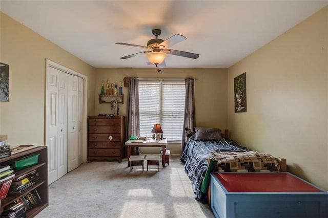 carpeted bedroom featuring ceiling fan and a closet