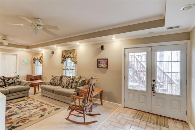 living room with ornamental molding, a raised ceiling, ceiling fan, and french doors