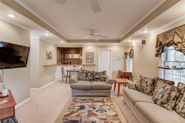 living room with crown molding, light colored carpet, a tray ceiling, and ceiling fan