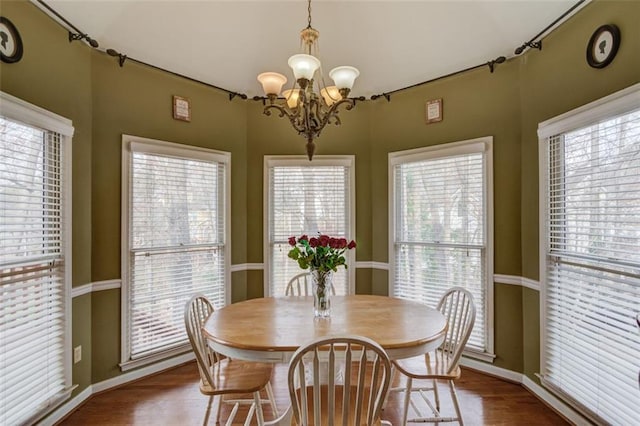 dining space featuring hardwood / wood-style flooring and a notable chandelier