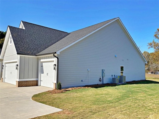 view of property exterior featuring a lawn, central AC unit, and a garage