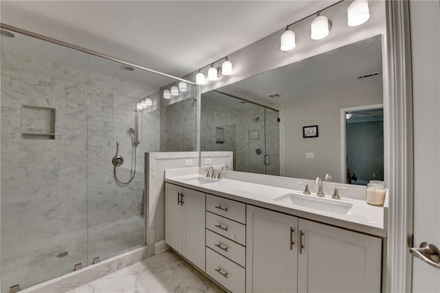 bathroom featuring marble finish flooring, double vanity, and a shower stall