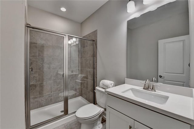bathroom featuring a stall shower, toilet, vanity, and tile patterned floors