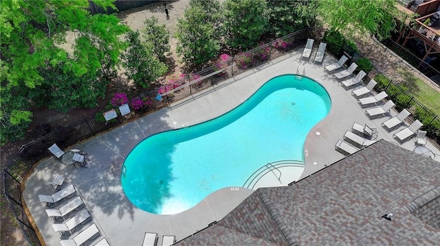 community pool with fence and a patio