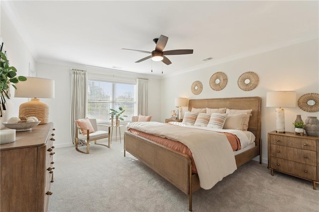 bedroom featuring a ceiling fan, light colored carpet, ornamental molding, and visible vents