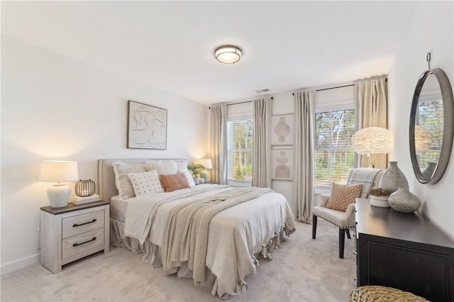 bedroom featuring baseboards, light carpet, and visible vents