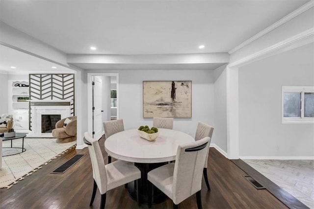 dining area featuring visible vents, baseboards, recessed lighting, a fireplace, and wood finished floors