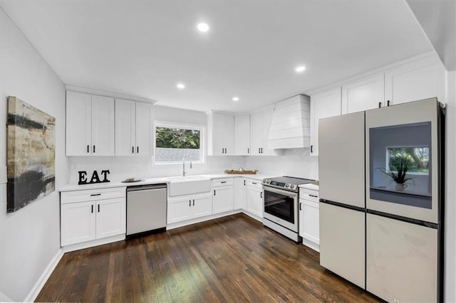 kitchen with custom range hood, a sink, dark wood-style floors, stainless steel appliances, and light countertops