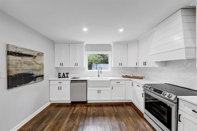 kitchen with dark wood finished floors, a sink, stainless steel appliances, light countertops, and white cabinets