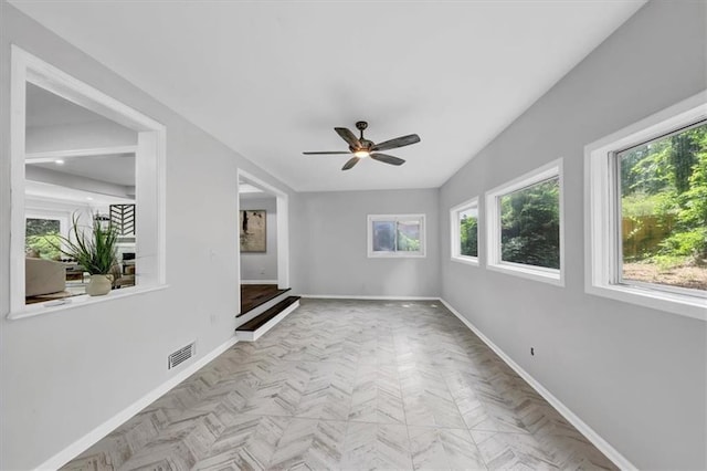 unfurnished room with a ceiling fan, baseboards, and visible vents