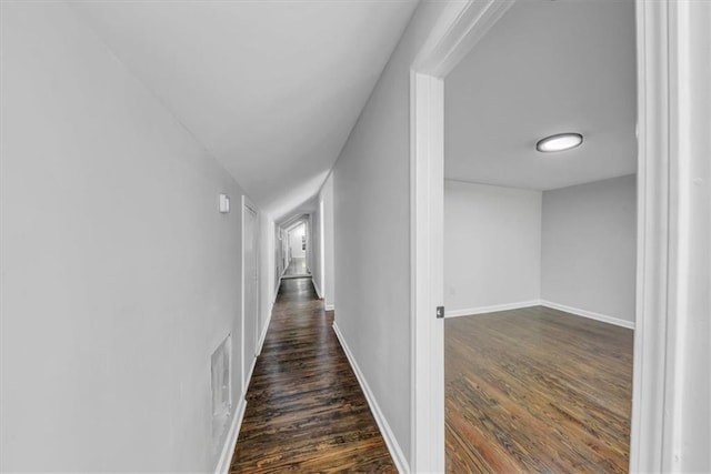 hall with dark wood finished floors and baseboards