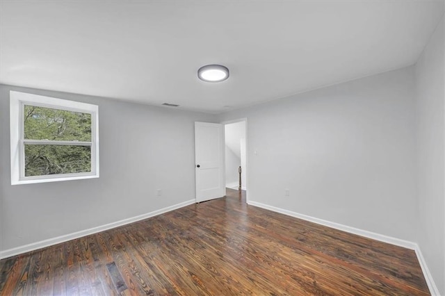 empty room with visible vents, baseboards, and wood finished floors