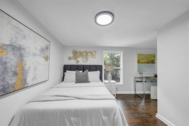 bedroom with baseboards and wood finished floors