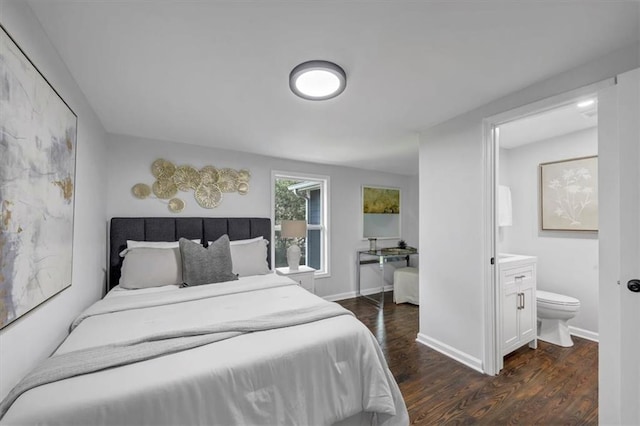 bedroom with connected bathroom, baseboards, and dark wood-style flooring