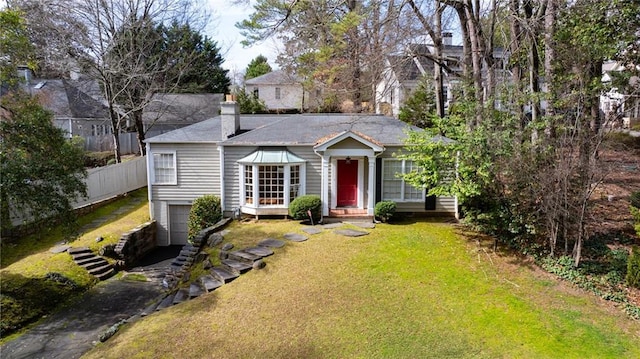 view of front of home featuring entry steps, an attached garage, fence, a chimney, and a front yard