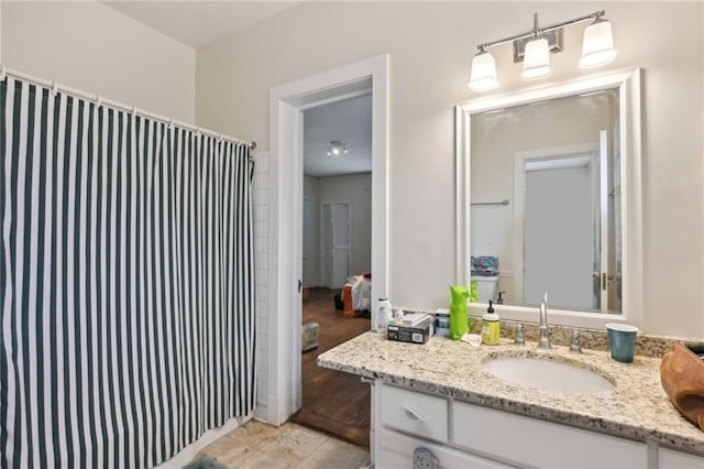 ensuite bathroom featuring a shower with curtain, tile patterned flooring, connected bathroom, and vanity