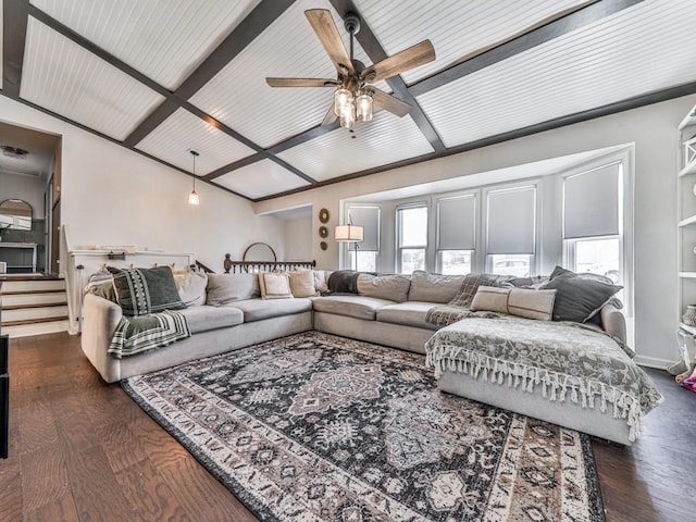 living room featuring stairs, plenty of natural light, dark wood finished floors, and vaulted ceiling with beams