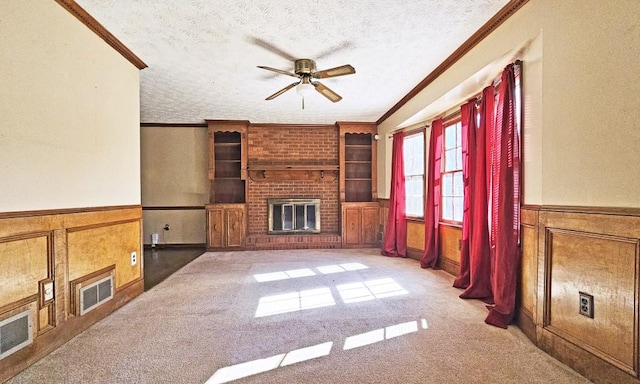 unfurnished living room featuring crown molding, carpet floors, a brick fireplace, and a textured ceiling