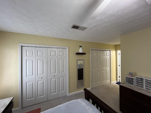 2529 Feathertree Ln, Lawrenceville, GA 30044 - bedroom featuring two closets, baseboards, carpet floors, and a textured ceiling