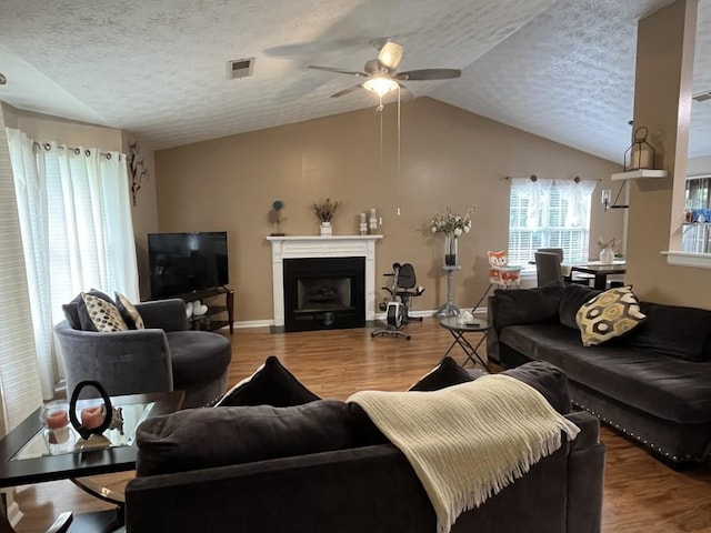2529 Feathertree Ln, Lawrenceville, GA 30044 - living area featuring vaulted ceiling, a ceiling fan, wood finished floors, a fireplace with flush hearth, and a textured ceiling