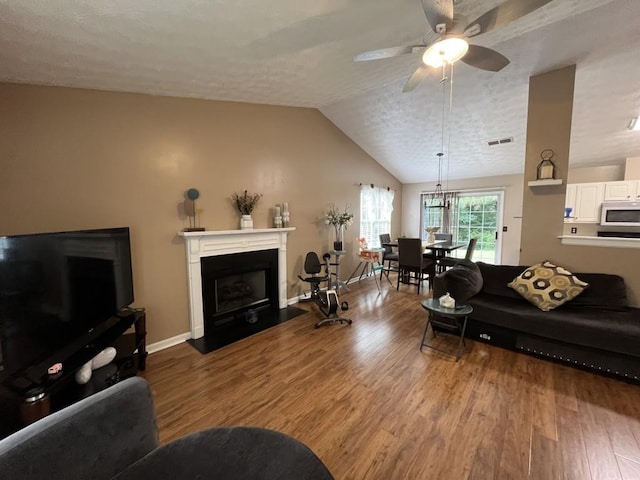 2529 Feathertree Ln, Lawrenceville, GA 30044 - living room with wood finished floors, a ceiling fan, a fireplace, lofted ceiling, and baseboards