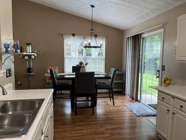 2529 Feathertree Ln, Lawrenceville, GA 30044 - dining space featuring vaulted ceiling, dark wood-style floors, a chandelier, and a textured ceiling