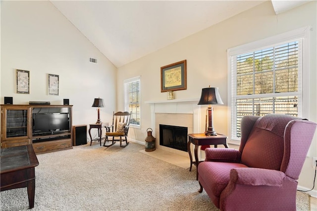 living area featuring high vaulted ceiling, light carpet, and a wealth of natural light