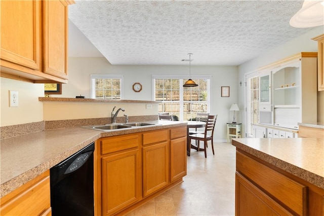 kitchen featuring pendant lighting, sink, a textured ceiling, and dishwasher