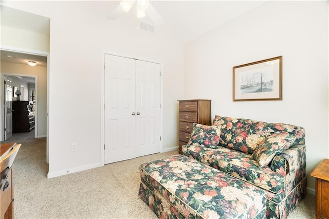 living area with ceiling fan and carpet