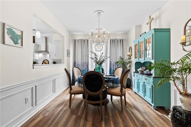 dining room featuring a notable chandelier, wainscoting, wood finished floors, and visible vents