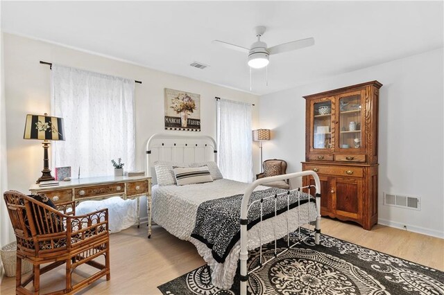 bedroom featuring visible vents, light wood-style flooring, and ceiling fan