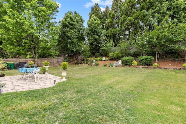view of yard with fence and a patio