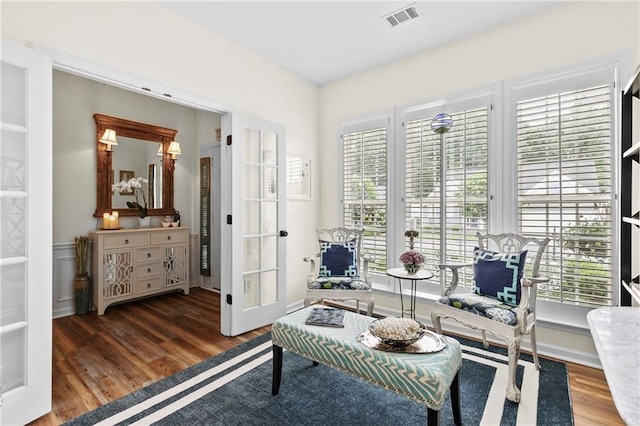 living area featuring visible vents, wood finished floors, and french doors