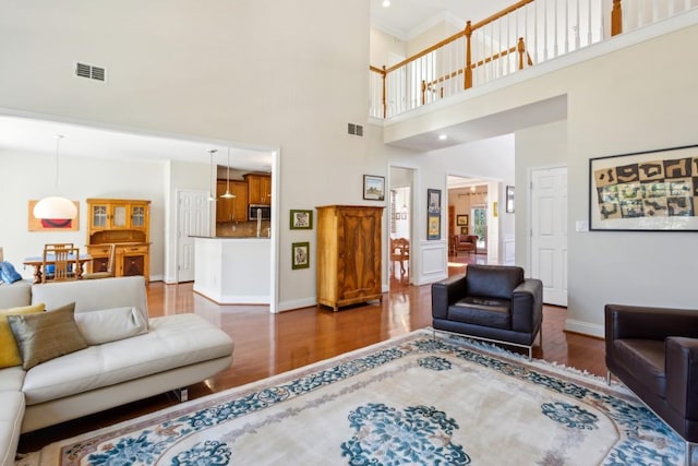 living room with hardwood / wood-style flooring and a towering ceiling