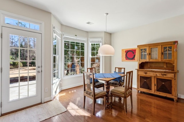 dining space with dark hardwood / wood-style flooring