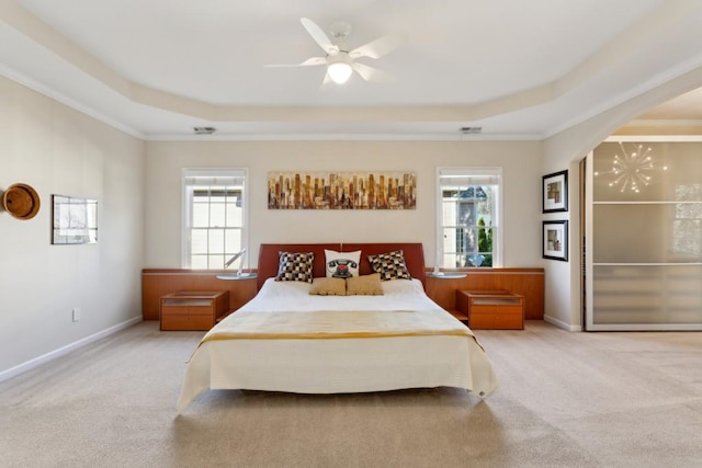 carpeted bedroom with ceiling fan, a tray ceiling, and multiple windows