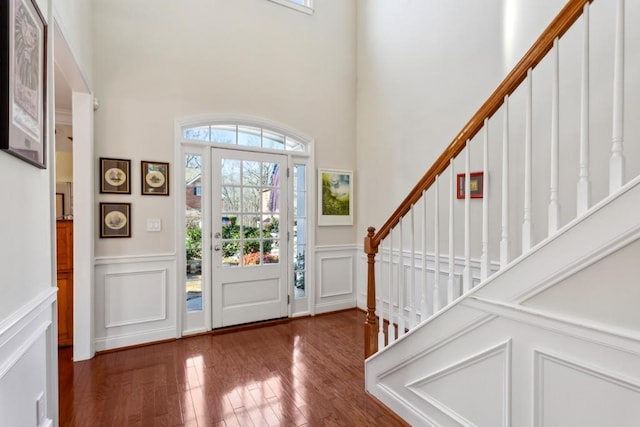 entryway featuring a towering ceiling, dark hardwood / wood-style floors, and a healthy amount of sunlight