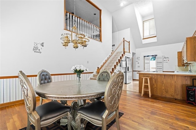1732 Winding Woods Ln, Jonesboro, GA 30236 - dining space with high vaulted ceiling, a skylight, light wood-style flooring, and stairway