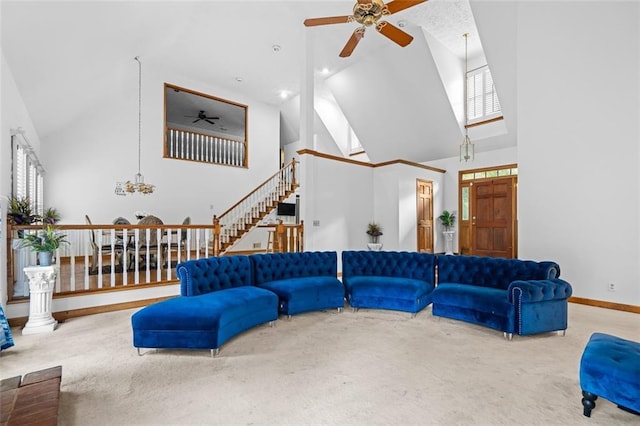 1732 Winding Woods Ln, Jonesboro, GA 30236 - carpeted living area with high vaulted ceiling, a ceiling fan, stairway, healthy amount of natural light, and a chandelier