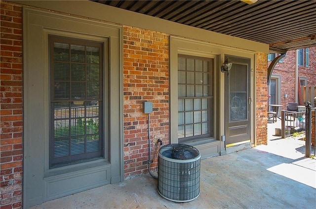 doorway to property featuring central AC unit and a patio