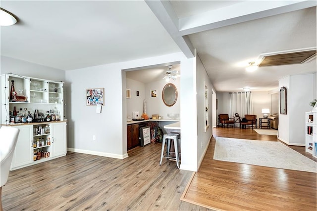 interior space featuring indoor bar, ceiling fan, and light wood-type flooring