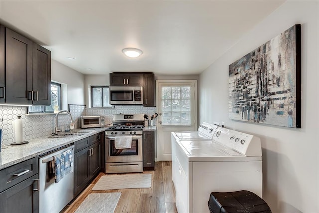 kitchen with stainless steel appliances, washing machine and dryer, backsplash, and dark brown cabinetry