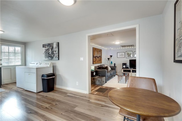 dining room with light hardwood / wood-style flooring and washer and dryer