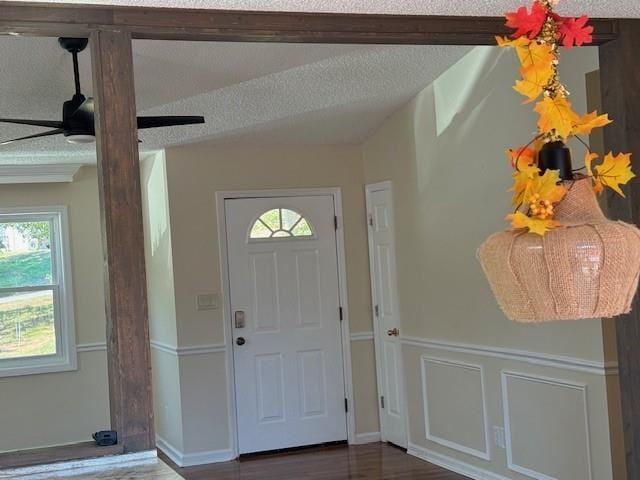 entrance foyer with a ceiling fan, a wealth of natural light, and wood finished floors