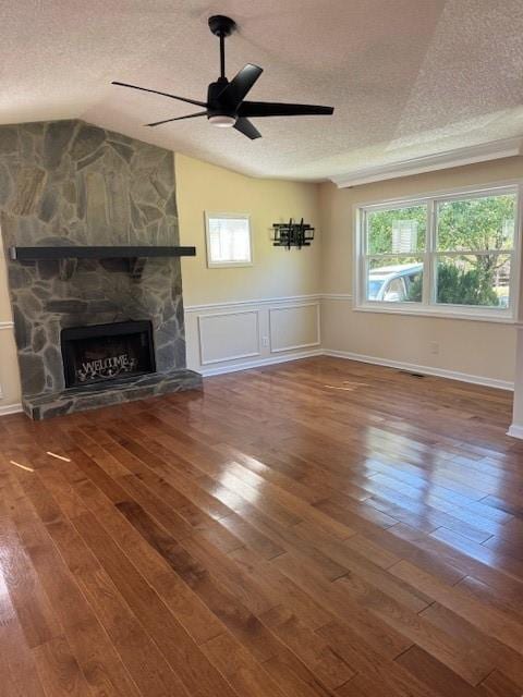 unfurnished living room featuring a ceiling fan, a textured ceiling, a fireplace, and hardwood / wood-style flooring