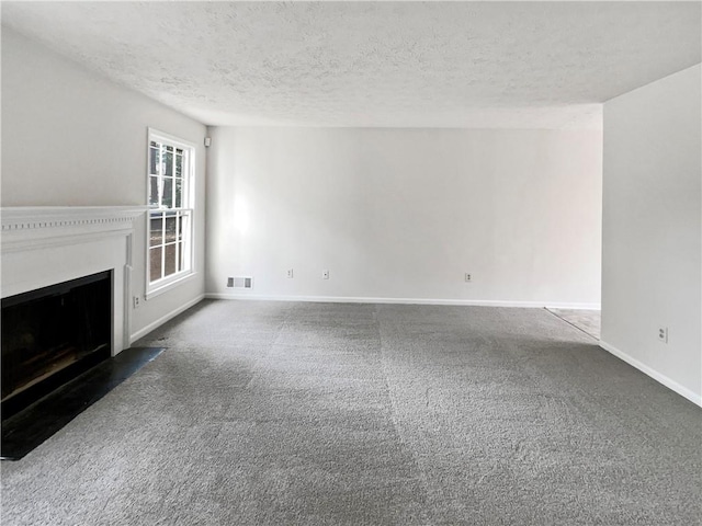 unfurnished living room featuring dark colored carpet and a textured ceiling