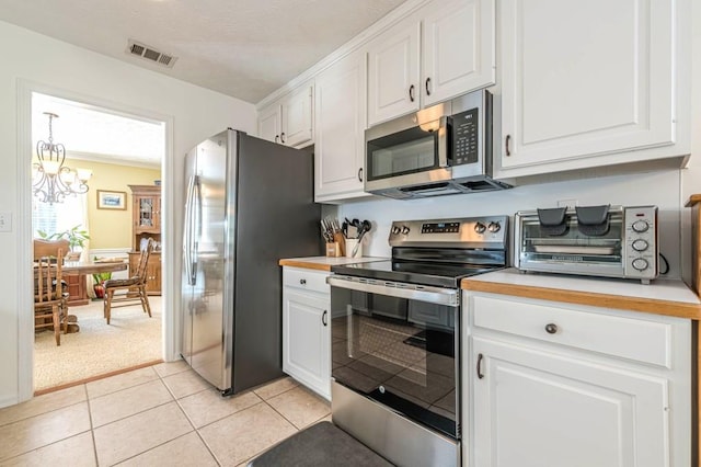 435 Flowering Trl, Grayson, GA 30017 - kitchen with appliances with stainless steel finishes, white cabinets, a chandelier, and light countertops
