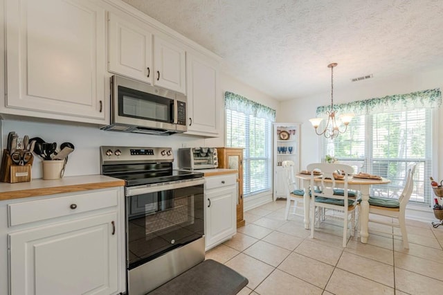 435 Flowering Trl, Grayson, GA 30017 - kitchen with stainless steel appliances, a chandelier, white cabinetry, light tile patterned flooring, and light countertops
